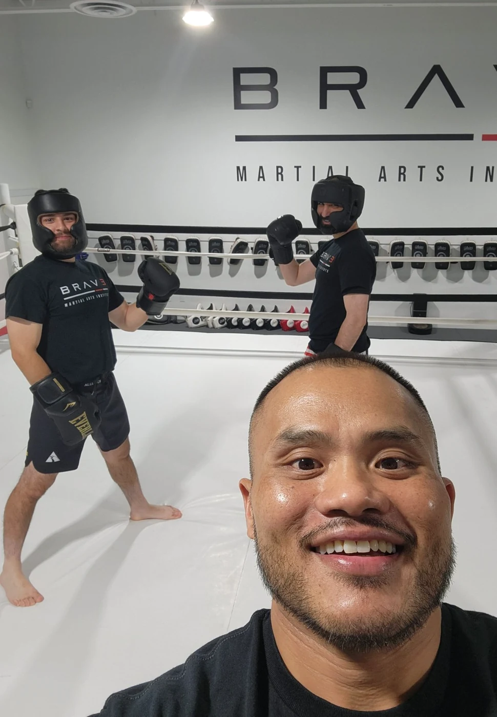 Coach Tony taking a selfie with two clients in the boxing ring