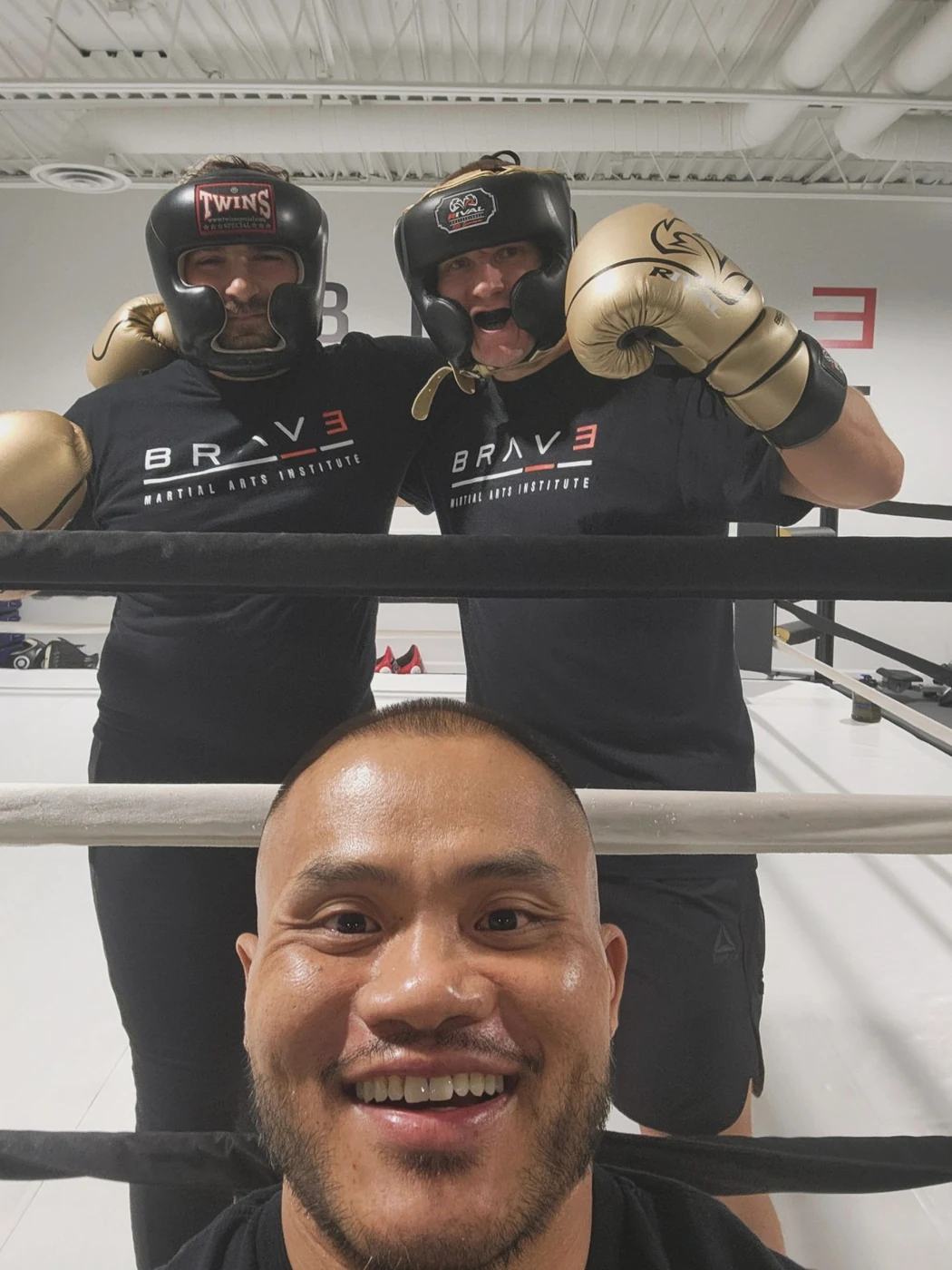 Coach Tony smiling in the ring with two training partners
